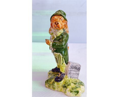 Anita Harris Ceramic figurine of a dog in a green coat, holding a book, with "DUBLIN" inscribed on the base. Signed "AHA" on 