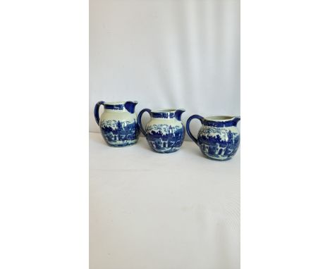 Set of three blue and white ceramic jugs featuring traditional landscape designs.