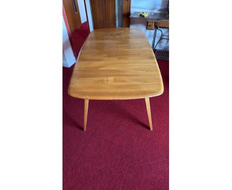 Ercol wooden dining table with extension leaf, light oak finish, tapered legs.