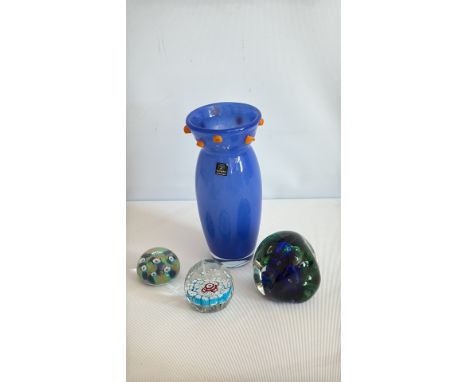 Antique glass paperweight with intricate floral design in blue, white, and red, featuring a green base with white flowers.