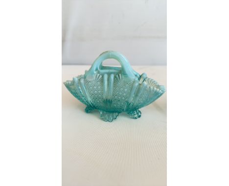 Pair of vintage turquoise glass baskets feature a diamond pattern with fan detailing, a handle, and three feet in an Art Deco