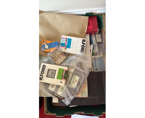 Mixed lot of photography supplies including Ilford film boxes, Gepe slide boxes, various manuals, and a photo album. Contains