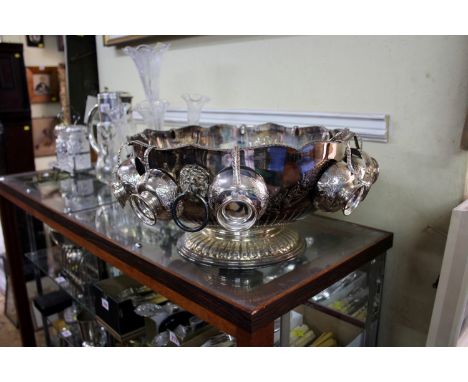 A plated punch bowl with punch cups and a ladle.