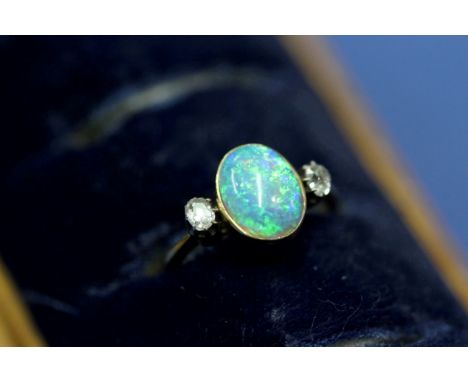 An 18ct gold ring set cabochon opal with diamond to each shoulder.   Condition Report:  No cracks to opal, minor scratching s