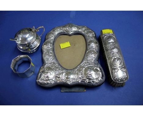 A silver photo frame; together with a silver mustard pot; silver napkin ring and a silver hair brush.