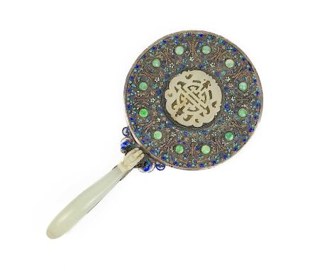 A Chinese silver and enamel mirror mounted with jade, late 19th century. The silver circular hand-mirror decorated with Buddh
