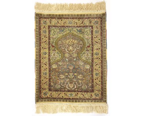 An exceptionally fine Hereke silk rug. the mihrab with signed cartouche and scrolling flowering vines and palmettes, the span