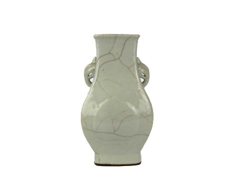 A Chinese celadon crackle-glazed porcelain hu-shaped vase, 19th century. With moulded elephant mask handles, with raised peac