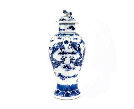 A Chinese porcelain baluster vase, late 19th century. With four character Kangxi mark, decorated with dragons chasing the fla