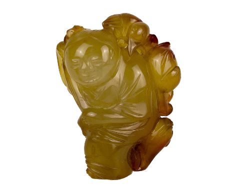 A Chinese jade and russet carving of a boy, Qing Dynasty. Holding a staff, with a bird on his shoulder and possibly a peach, 