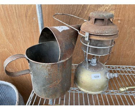 A VINTAGE OIL JUG AND A VINTAGE PARAFIN LAMP 