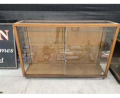 A LARGE VINTAGE SHOP DISPLAY UNIT WITH SLIDING GLASS DOORS AND INTERNAL GLASS SHELVES 