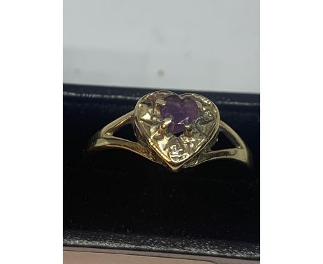 A 9 CARAT GOLD RING WITH A PURPLE STONE AND DIAMONDS IN A HEART DESIGN SIZE M WITH A PRESENTATION BOX 