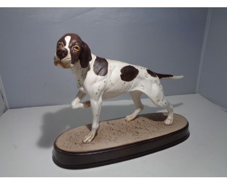 A BESWICK POINTER ON A CERAMIC PLINTH 