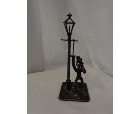 A MODEL OF A MAN DRINKING UNDER A LAMP POST MADE FROM NUTS, BOLTS, SCREWS, ETC 