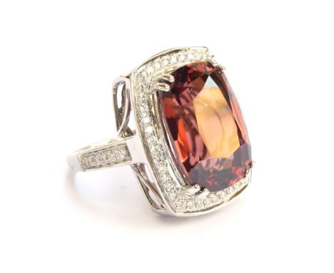 An 18ct white gold ring set with a large Ratanakiri red zircon and diamonds, the zircon 19.5cts and measuring 17x12mm, the di