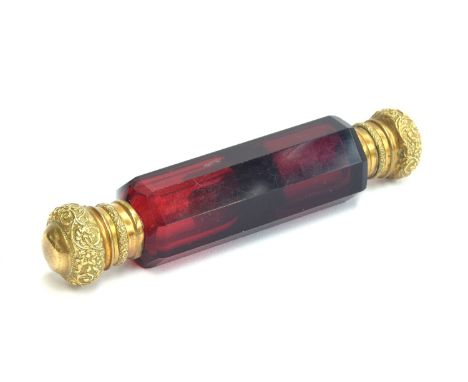 A ruby glass double ended scent bottle, each end with chased gilt metal hinged caps, 12.4cm long 