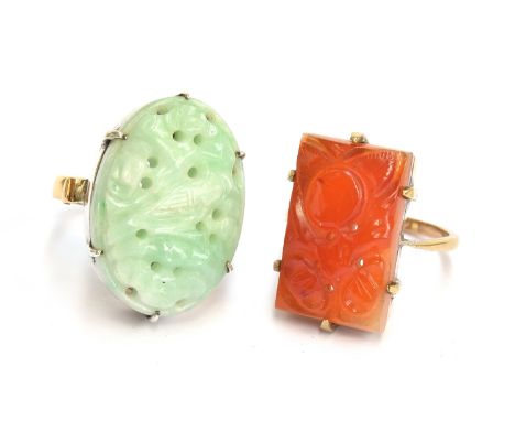 A Chinese carved and pierced jade panel ring depicting a bird amongst foliage, claw set in white metal, on a hallmarked 22ct 