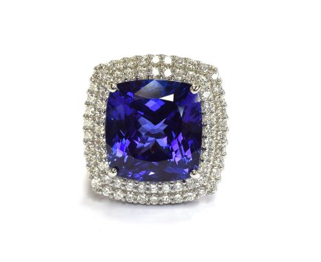 A platinum mounted tanzanite and diamond cluster ring, the large cushion cut tanzanite measuring approx. 12x13mm and weighing