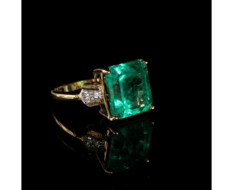 An 18ct gold, emerald and diamond ring, the Muzo Colombian emerald 8.69cts and 12.5x12mm, size N 1/2, gross weight 6.4g, purc