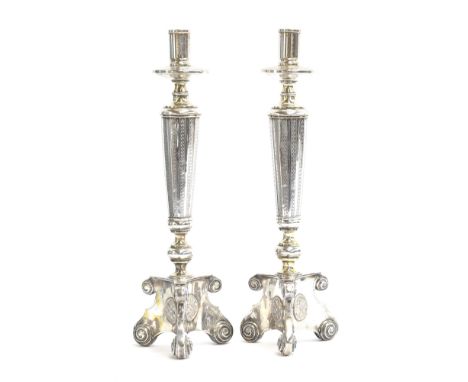 A pair of continental silver plated candlestick on triform bases with floral roundels, in the manner of alter sticks, 40cm hi