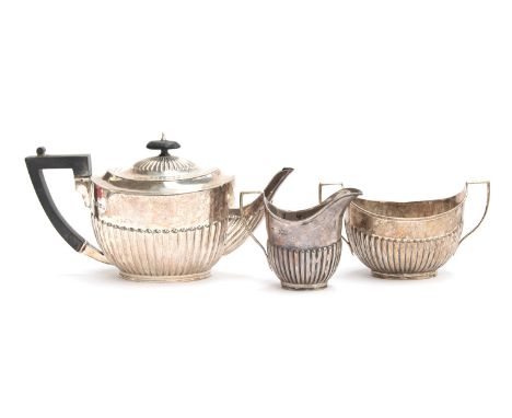 A late Victorian three piece silver tea set by William Hutton &amp; Sons Ltd, London 1899, comprising teapot, milk jug, and s
