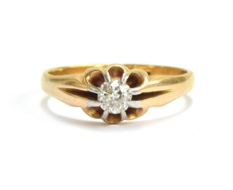 An early 20th century 18ct gold diamond solitaire ring in a buttercup setting with platinum tipped claws, the diamond approx.