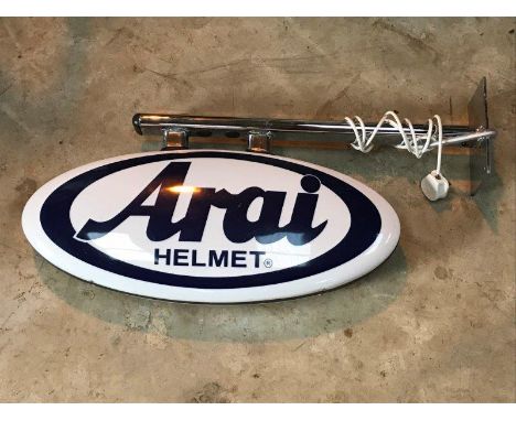 An oval illuminated double sided lightbox advertising Arai Helmet, on a chromed bracket.