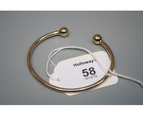 A 9ct gold bangle, plain with spherical terminals 14.5g