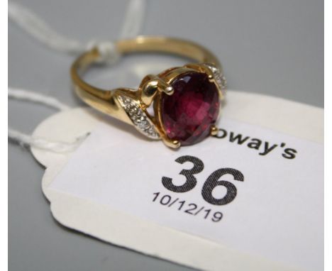 A single stone pink tourmaline ring, the chequerboard oval cut stone in four claw mount with diamond set scrolling shoulders 