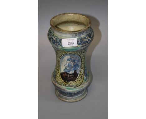 An Italian Albarello jar painted with a panel of a monk in profile within leafy borders, 25cm high