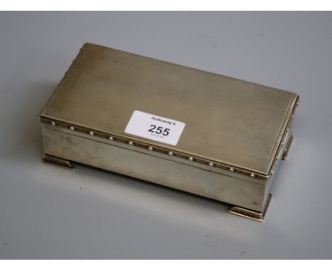A silver cigarette box, rectangular, engine turned with applied Celtic borders and Celtic bracket feet, cedar lined, Birmingh