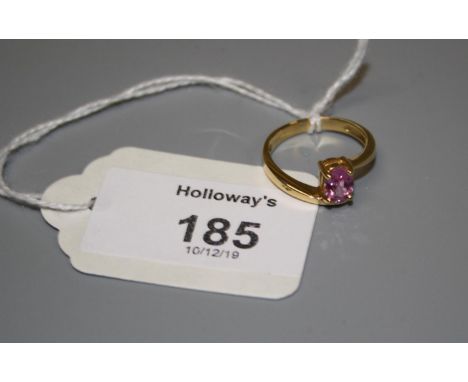 A single stone pink sapphire ring, the oval cut set sapphire within an 18ct gold cross-over mount,  Ring size O, 3.8g