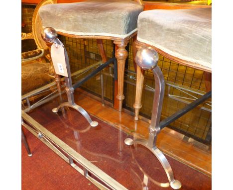 A collection of modern fireside tools including fire dogs