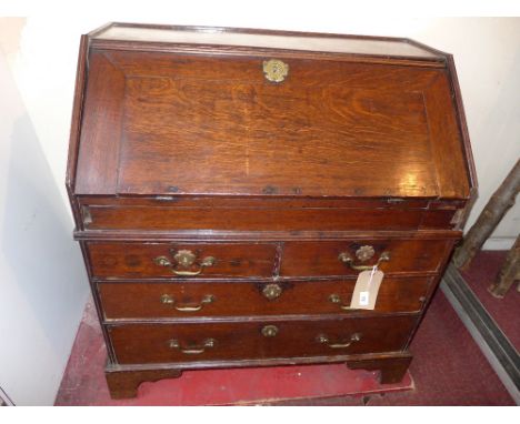 An 18th century oak bureau the fall front and fitted interior above two short and long drawers on bracket feet