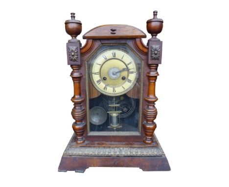 A Edwardian stained wood mantel alarm clock, cream dial with Roman numerals, with pendulum and key.
