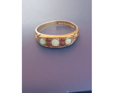 A small opal &amp; ruby set 9ct gold ring - London marks. Finger size N/O.