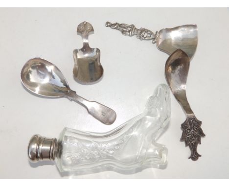 A moulded glass shoe-shaped scent bottle with London silver lid and four white metal/EP caddy spoons - one repaired. (5)