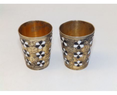 A pair of French silver-gilt tot measures decorated in black &amp; white cloisonne enamel flowers,  1.9" high. (2)