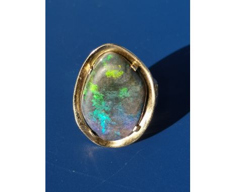 An 18ct gold ring set with a large free-form black opal.  Finger size K/L.