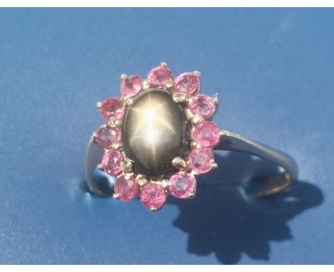 A small ruby cluster ring with central 'star' cabochon.  Finger size Q.