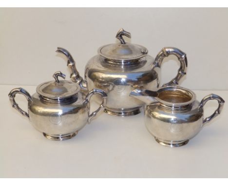 A Chinese three piece silver tea service, having bamboo moulded handles and spout to teapot, the rounded sides finely hammere