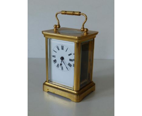 A brass carriage clock - 'ACCL' with white enamel dial,  4.25" high excluding handle.