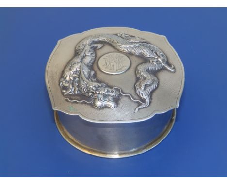 A Chinese silver circular jar, the detachable lid of cartouche outline with central monogrammed plaque surrounded by bold rel