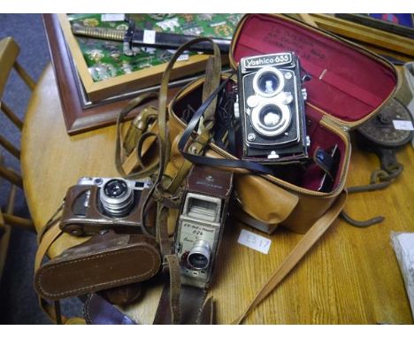Collection of vintage camera equipment including Zorki-6 camera in case, The G B Bell and Howell 624 8mm camera, and the Yash