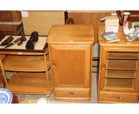 A blond Ercol cabinet with lifting top, cupboard and single drawer below 