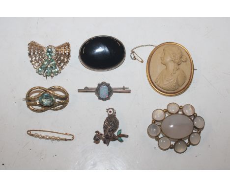 A yellow metal clip set with blue and white stones; a yellow metal mounted cameo brooch; a moonstone style brooch; an opal do