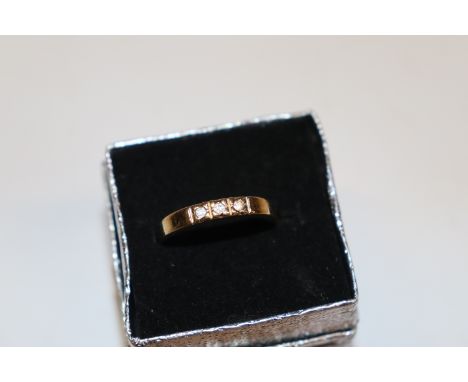 A yellow metal ring set with white stones