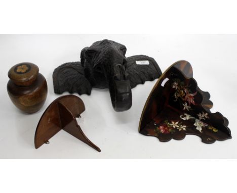 A WOOD CARVING IN THE FORM OF A ELEPHANTS HEAD, 32cm wide together with a treen tea caddy and two painted wooden wall bracket