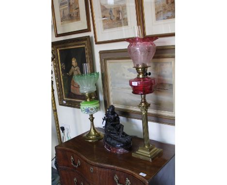 TWO VICTORIAN BRASS OIL LAMPS one with a Corinthian column support to the cranberry glass oil reservoir and etched shade and 